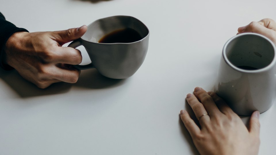 コーヒーを前に向かい合って話す二人