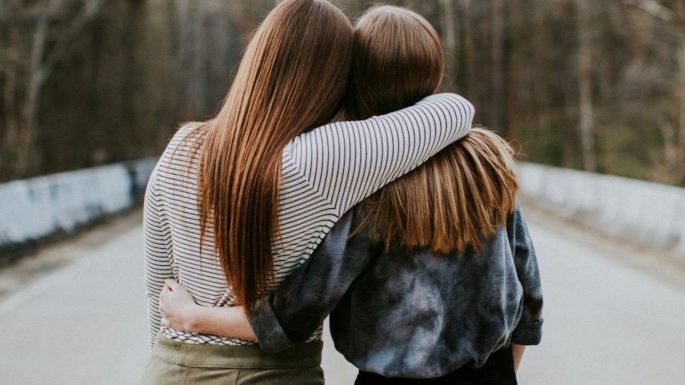 抱き合って励まし合う二人の友人
